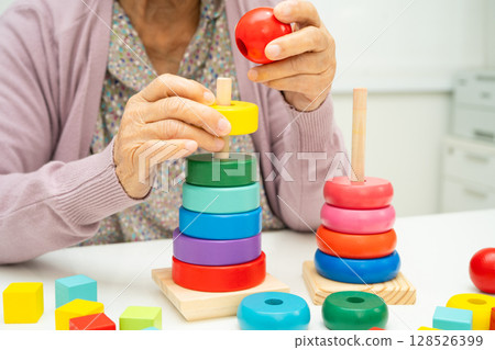 Asian elderly woman patient suffering from dementia learn practical motor skills rehabilitation. 128526399