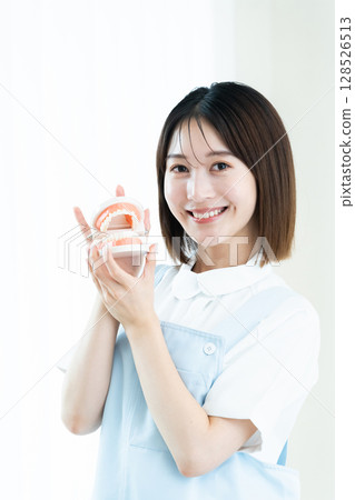 牙科工作人員拿著牙齒模型 128526513
