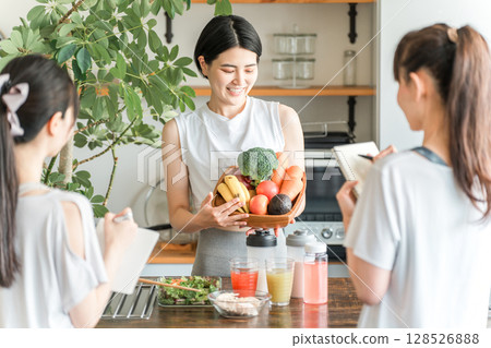 An athlete food master explains the nutritional value of vegetables, green and yellow vegetables, and fruits in a cooking class. 128526888