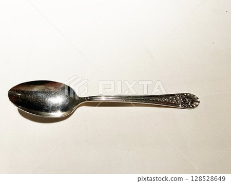 Silver spoon on a white table 128528649