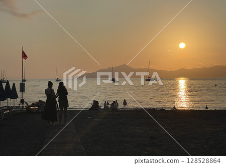 Beach at sunset time in summer on beach. Nature and mountains. Vacation in Liguria, Italy. Background for text. Beach at sunset time in summer on beach. Nature and mountains. Vacation in Liguria, Italy. Background for text. 128528864