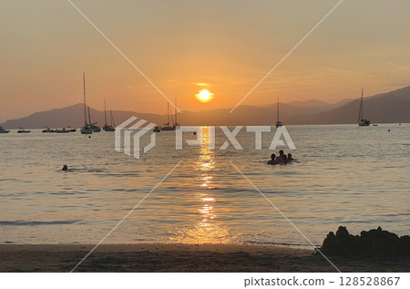 Beach at sunset time in summer on beach. Nature and mountains. Vacation in Liguria, Italy. Background for text. Beach at sunset time in summer on beach. Nature and mountains. Vacation in Liguria, Italy. Background for text. 128528867