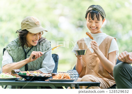 A friendly family enjoying day camping, camping and barbecues at a park or campsite 128529632