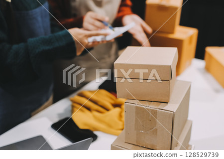 Portrait of Starting small businesses SME owners, two Asian woman check online orders Selling products working with boxs freelance work at home office, sme business online small medium enterprise 128529739