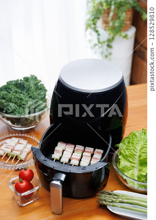 Pork belly skewers cooking in an air fryer 128529810
