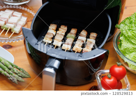 Pork belly skewers cooking in an air fryer Pork belly skewers cooking in an air fryer 128529813