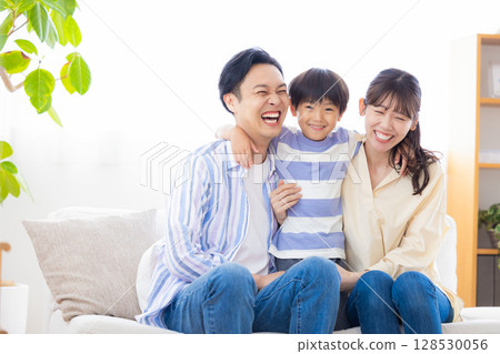 Family portrait of a family sitting on a sofa 128530056