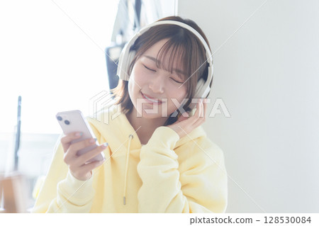 A woman who plays headphones A woman who plays headphones 128530084