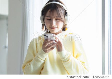 一個操作智能手機的年輕女子 128530086
