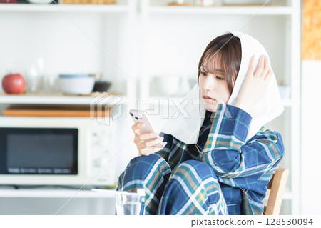 A woman watching a smartphone A woman watching a smartphone 128530094