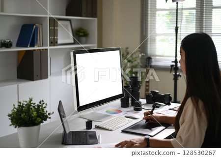 Photographer working in a creative studio with camera gear on the desk Photographer working in a creative studio with camera gear on the desk 128530267