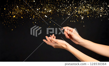 A landscape with two hands waving a magic wand while scattering gold dust 128530364