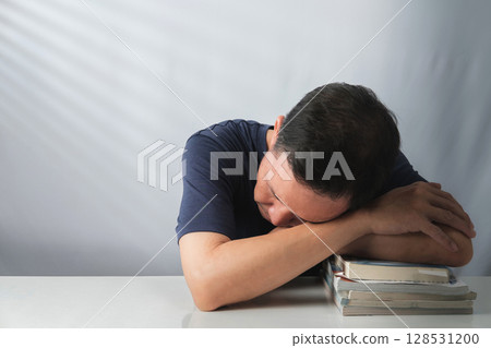 Asian Man Napping on Books 128531200