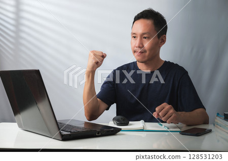 Middle-aged Asian home office man who is successful in working online 128531203