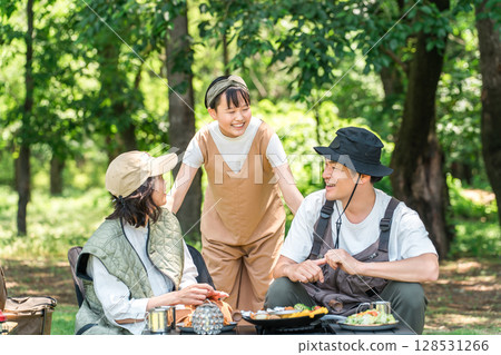 A friendly family enjoying day camping, camping and barbecues at a park or campsite A friendly family enjoying day camping, camping and barbecues at a park or campsite 128531266