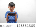 Asian Boy Playing Game Mobile Phone in Landscape Mode. Technology Use in Childhood 128531385