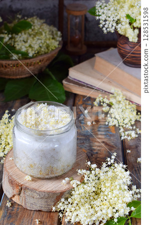 Elderflower sugar and blossom flower in wooden background. Edible elderberry flowers add flavour and aroma to drink and dessert. Copy space Elderflower sugar and blossom flower in wooden background. Edible elderberry flowers add flavour and aroma to drink and dessert. Copy space 128531598