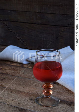 A glass of red wine on rustic wood table. Valentines Day, Birthday, Mother's day, March 8, Wedding still life. Concept greeting card. Copy space for text A glass of red wine on rustic wood table. Valentines Day, Birthday, Mother's day, March 8, Wedding still life. Concept greeting card. Copy space for text 128531606
