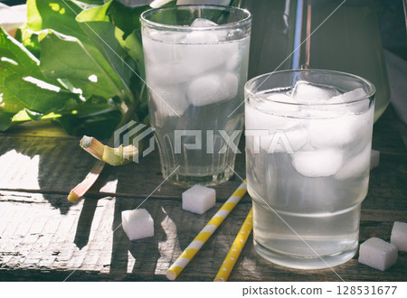 Refreshing healthy summer drink with rhubarb. Pieplant lemonade in glass on wooden background. Homemade rhabarbarum compote. 128531677