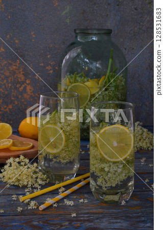 Elderberry flowers and lemon drink. Refreshment healthy elder juice. Glass of elderflower lemonade on wooden rustic board. Alternative medicine and therapy 128531683