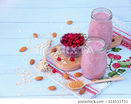 healthy smoothies from berries, oatmeal, nuts and brown sugar on a light wooden background. healthy smoothies from berries, oatmeal, nuts and brown sugar on a light wooden background. 128531731