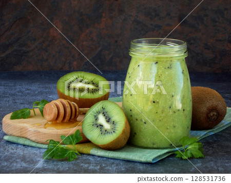 healthy green smoothies from kiwi, oatmeal, nuts and honey on dark background. 128531736