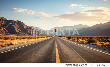 A hot air balloon floating on the other side of a road 128531879
