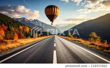 A long, straight road stretches out, and a hot air balloon is floating in the distance. 128531882