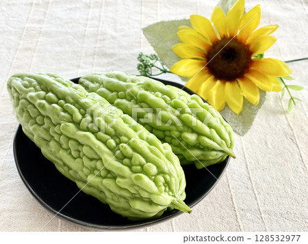 Two bitter melons and a sunflower 128532977