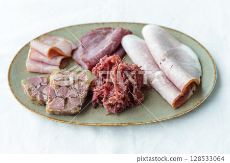 Ham, corned beef and meat terrine on a plate 128533064
