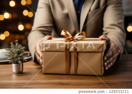 A man's hands holding a gift box with a bow .Generative AI 128533211