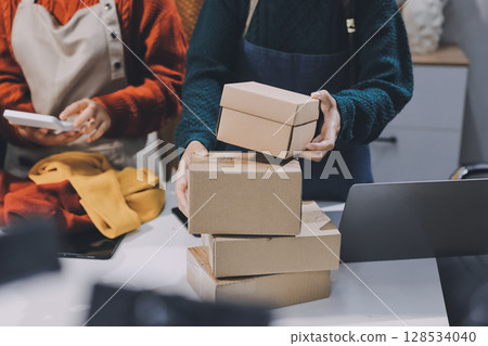 Portrait of Starting small businesses SME owners, two Asian woman check online orders Selling products working with boxs freelance work at home office, sme business online small medium enterprise 128534040
