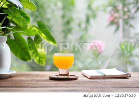 Orange juice and notebook with potted philodendron plant Orange juice and notebook with potted philodendron plant 128534530