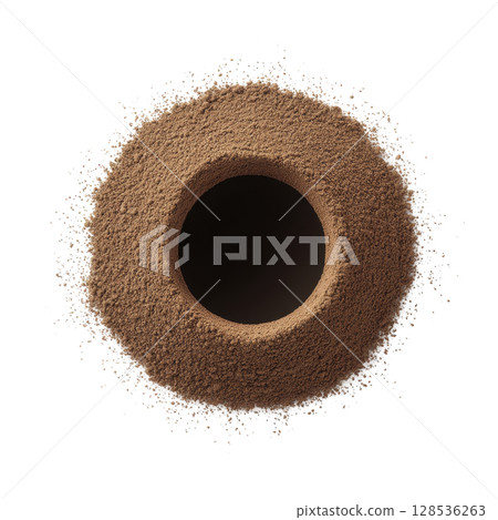 Circular mound of brown powder is surrounded by scattered dusting, creating textured and dynamic visual. central void adds depth and contrast to composition 128536263