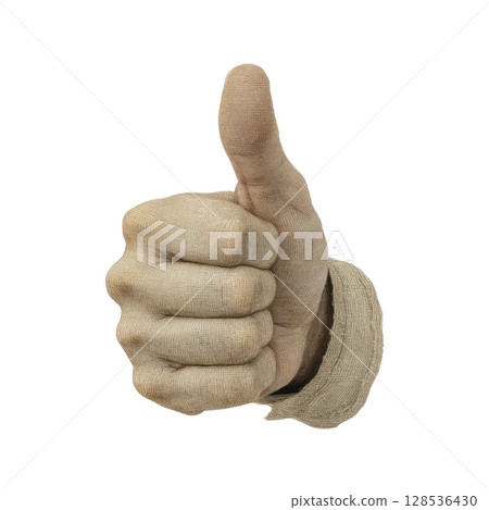 Hand wearing beige glove gives thumbs up gesture, symbolizing approval or agreement. glove has textured fabric appearance, adding rustic feel to image 128536430