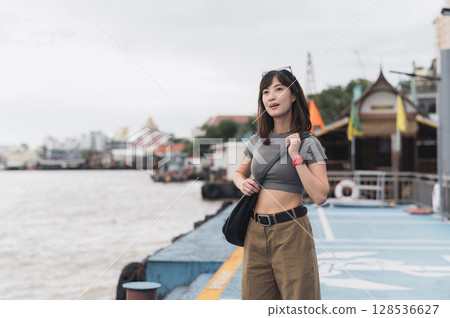 Solo Southeast Asian woman teenager blogger and world travel explorer wait for express boat. local cultural tourism concept on Chao Phraya River in Bangkok Thailand an Asia travel experience Solo Southeast Asian woman teenager blogger and world travel explorer wait for express boat. local cultural tourism concept on Chao Phraya River in Bangkok Thailand an Asia travel experience 128536627