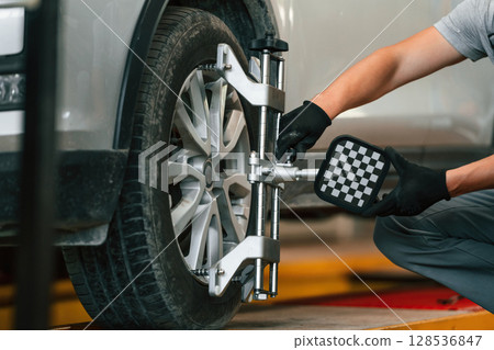 Adjusting the tire. Man is works in the automobile repairing salon 128536847