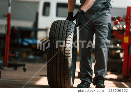 Close up view of moving the wheel. Man is works in the automobile repairing salon 128536862
