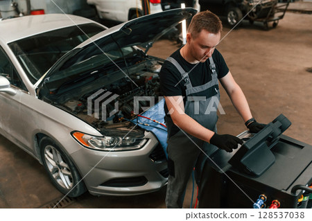 Man is works in the automobile repairing salon Man is works in the automobile repairing salon 128537038