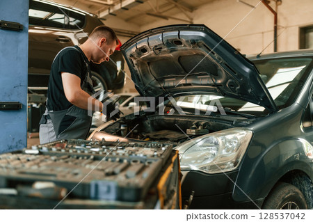 Under the hood. Man is works in the automobile repairing salon 128537042