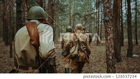 Group of Soldiers Walking Through Forest with Rifles 128537234