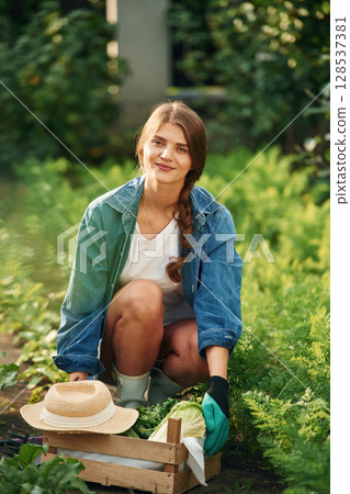 Smiling and sitting. Beautiful young woman is gardening 128537381