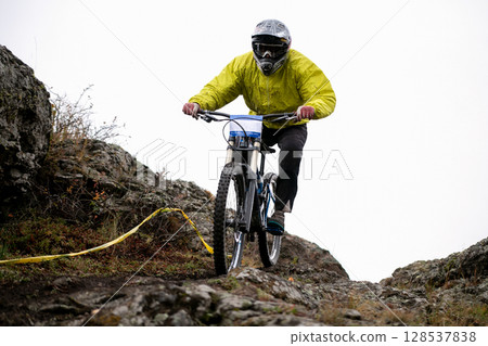 extreme mountain biker riding on rocky trail during downhill competition 128537838