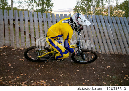 extreme mountain biker riding downhill on turn trail during race competition 128537840