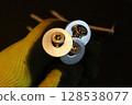 Construction worker holding large bolts with washers. Construction work process. 128538077