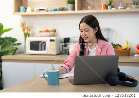 Working from Home: Woman studying with laptop and coffee Working from Home: Woman studying with laptop and coffee 128538201