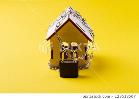 Housing arrest. Castle house. Small toy house and a chain with a lock. 128538507