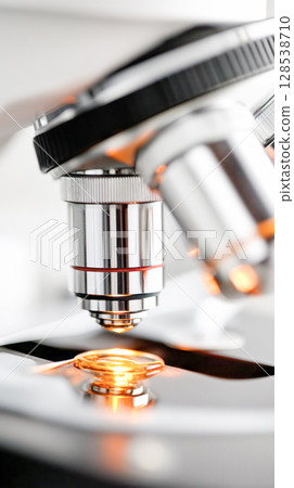 Close-up view of a modern microscope showcasing intricate details of the lens and light source, emphasizing scientific exploration and discovery 128538710