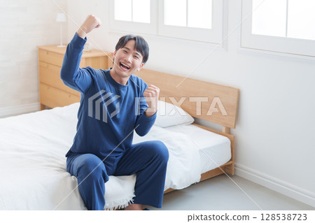Smiling man doing fist pump in bed Smiling man doing fist pump in bed 128538723