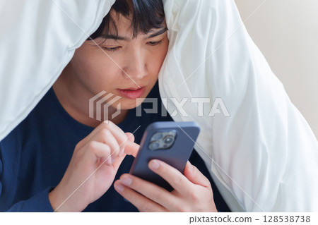 男人在床上使用智慧型手機 128538738